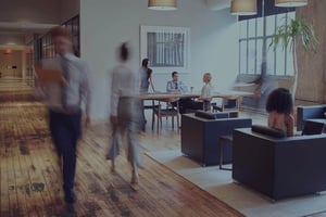 People walking through a bright open-plan office lounge